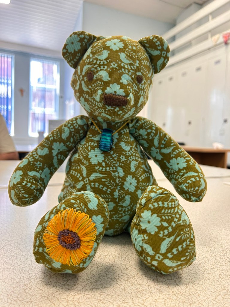 A patterned bear with embroidered sunflower